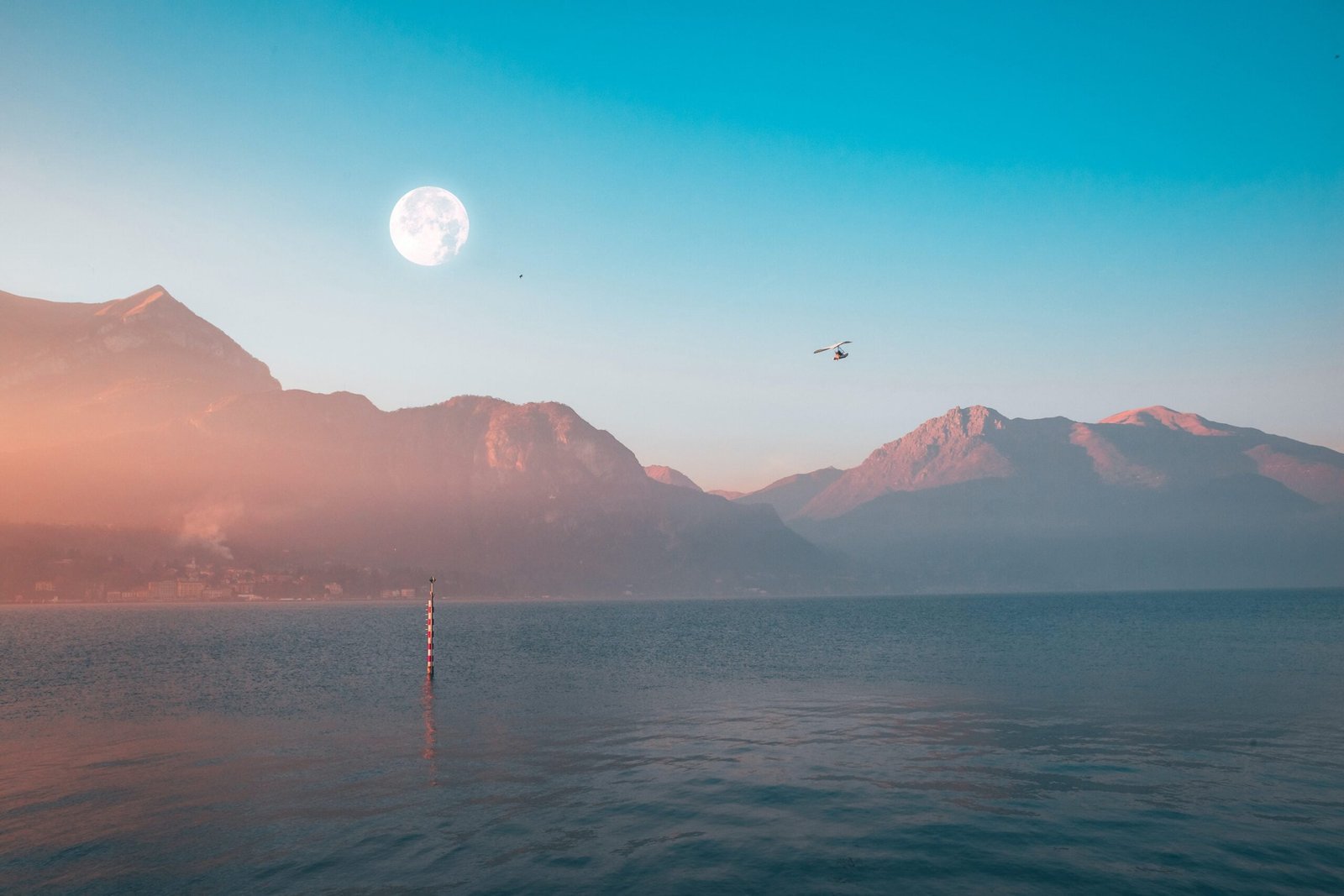A dreamlike horizon with mountains a moon and someone flying