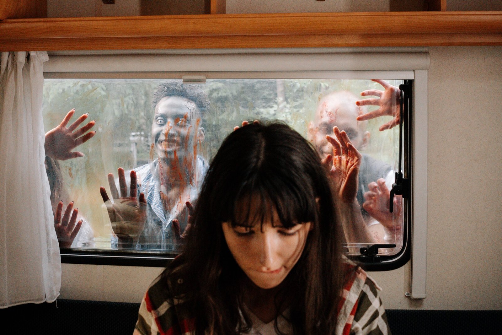 Zombies looking in a window on a mobile home