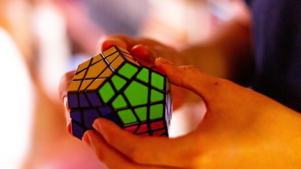 Hands solving an advanced version of a rubriks cube