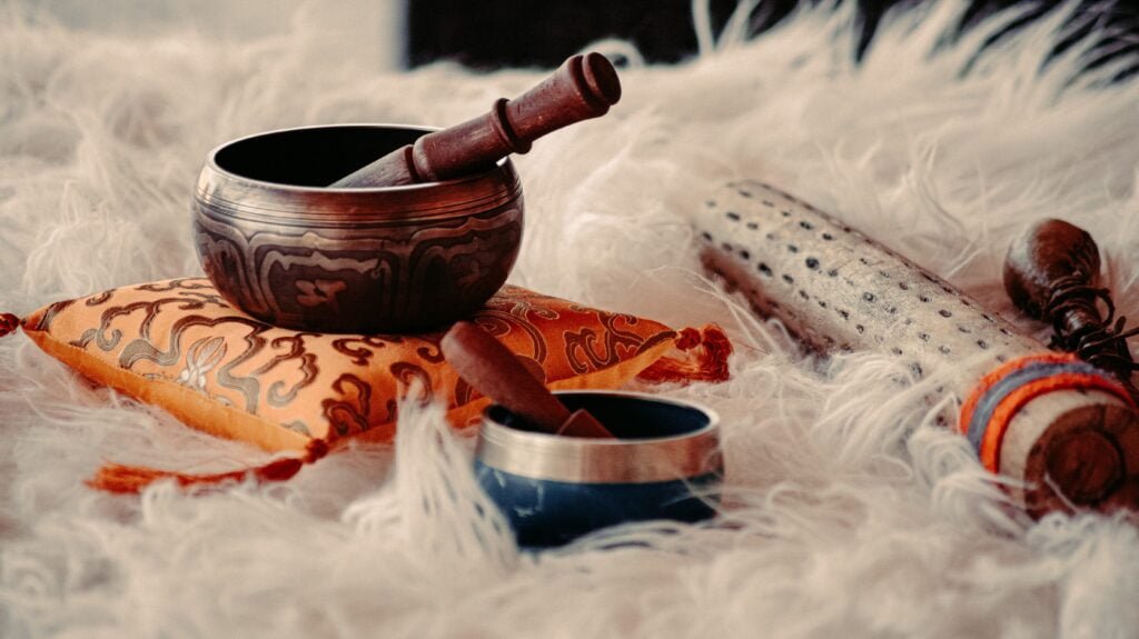 A singing bowl and other instruments sitting on a rug