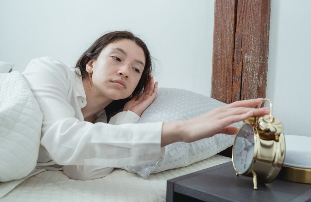 A woman has just been woken up by her alarm clock