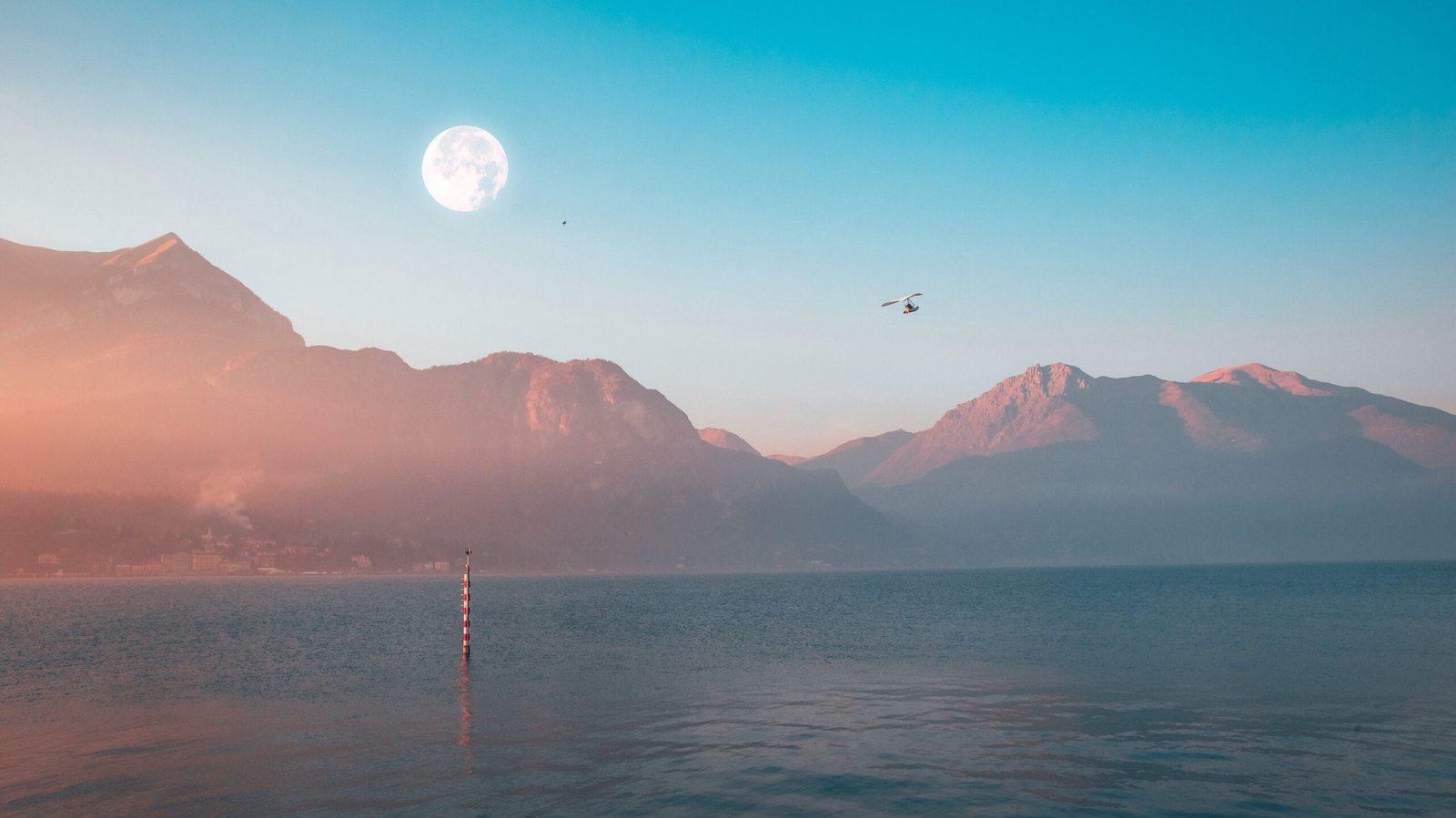 A dreamlike horizon with mountains a moon and someone flying