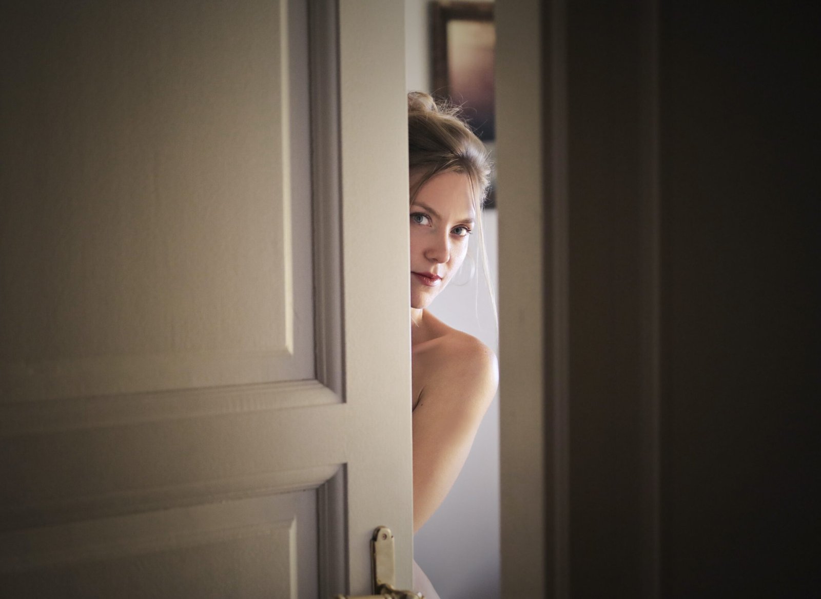 A woman peeking into a hidden room