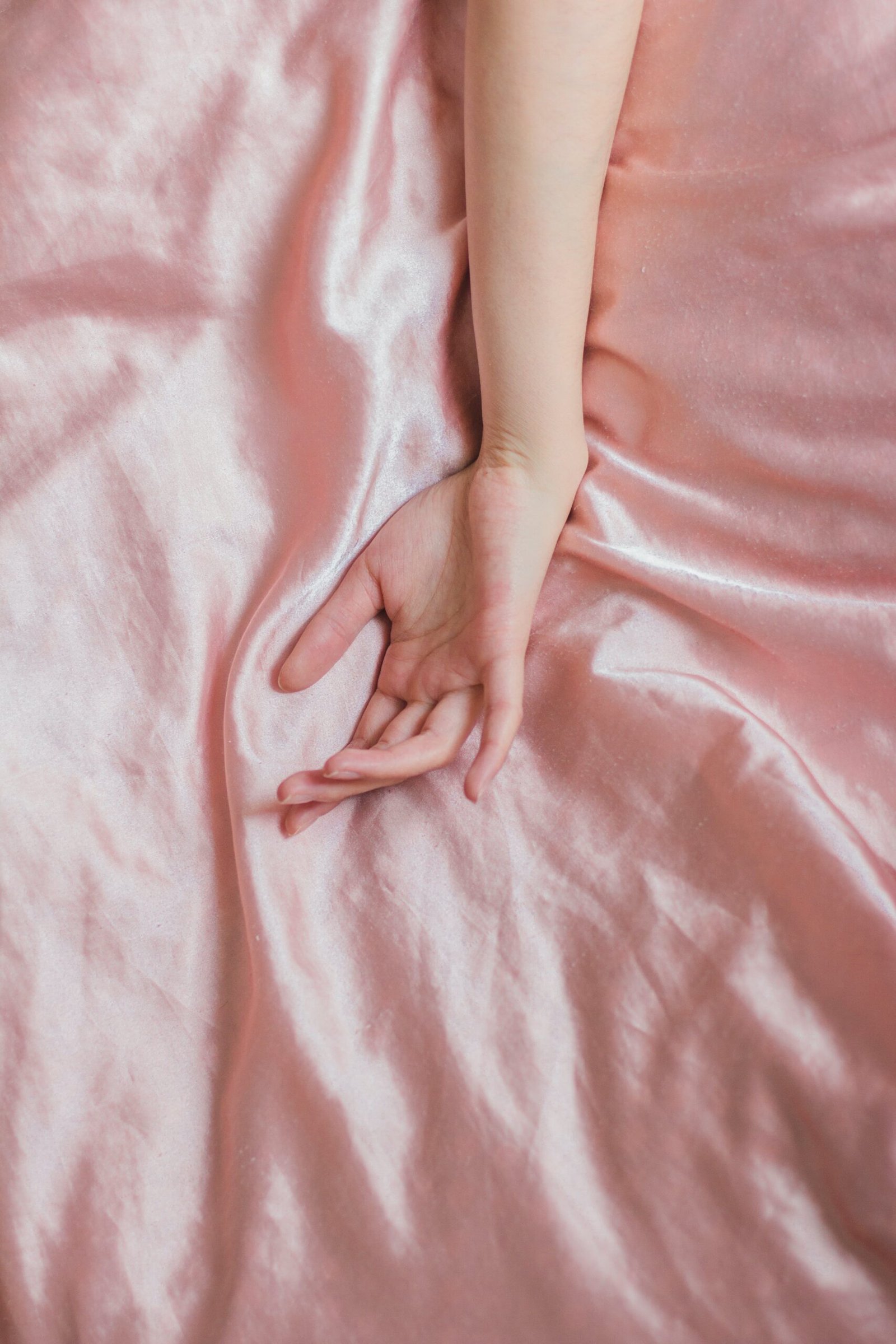A womans hand in bed illustrating progressive muscle relaxation.